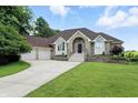 Charming brick home featuring a well-manicured lawn and a two-car garage with beautiful shrubbery at 1326 Pebble Brook Dr, Noblesville, IN 46062