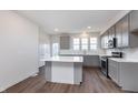 Bright kitchen showcases gray cabinets, white countertops, stainless steel appliances, and an island with seating at 14521 Hanford Ln, Carmel, IN 46074