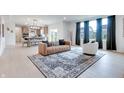 Open-concept living room showcasing a stylish rug, comfortable seating, and a view of the modern kitchen at 15192 Montfort Dr, Noblesville, IN 46062