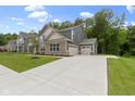 Charming two-story home featuring a three-car garage, brick accents, concrete driveway, and lush green lawn at 15546 Senita Ln, Fishers, IN 46037