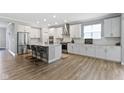 Modern kitchen featuring white cabinets, granite countertops, stainless steel appliances, and a center island with seating at 15546 Senita Ln, Fishers, IN 46037