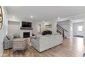 Cozy living room with a fireplace, recessed lighting, hardwood floors, and comfortable seating arrangement at 15546 Senita Ln, Fishers, IN 46037