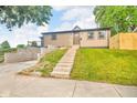 Charming home with a landscaped front yard and a staircase leading to the entrance at 1555 N Dearborn St, Indianapolis, IN 46201