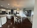 A bright and airy kitchen with a dining area, featuring white cabinetry, stainless steel appliances, and hardwood floors at 15961 Foothill Dr, Noblesville, IN 46060