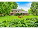 Lush backyard featuring well-maintained lawn, mature plants, and comfortable seating area at 1660 Obara Ct, Carmel, IN 46033