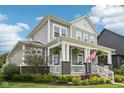 A gray two-story home has a charming front porch with lush green landscaping around the house at 2105 Granville Dr, Westfield, IN 46074