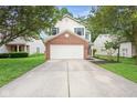 Inviting two-story home boasts a two-car garage, tidy lawn, and mature trees surrounding the property at 2289 Salem Park Dr, Indianapolis, IN 46239