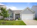 Charming single-story home featuring stone accents, gray siding, and a well-manicured front yard at 2421 Creek Bank Dr, Columbus, IN 47201