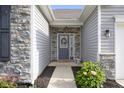 Inviting front entrance with a decorative wreath, stone accents, and a cozy bench at 2421 Creek Bank Dr, Columbus, IN 47201