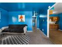 Bright blue living room leading into the kitchen with minimalist decor and carpet floors at 2610 Caroline Ave, Indianapolis, IN 46218