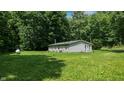 Backyard of a single-story home with a lush lawn and mature trees providing privacy and shade at 290 S Buffalo Hill Rd, Martinsville, IN 46151