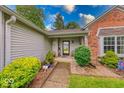 Inviting front porch adorned with potted plants, seating, and landscaped bushes, leading to the front door at 3025 Sable Ridge Ln, Greenwood, IN 46142