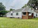 Rear view of the home featuring a well-maintained lawn and vinyl siding at 313 S Brittain Ave, Muncie, IN 47303