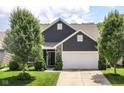 Charming home with a brown door, manicured lawn, and attached two-car garage on a sunny day at 561 Farnham Dr, Westfield, IN 46074