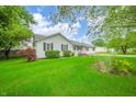 View of the white-sided single-story home and landscaping on a sunny day at 610 E 1000 N, Fortville, IN 46040