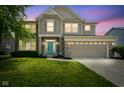 Charming two-story home at dusk featuring a manicured lawn, a two-car garage, and a welcoming turquoise-colored front door at 6471 W Clearview Dr, McCordsville, IN 46055