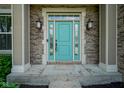 Close up of turquoise front door with decorative sidelights and a brick surround framed by stately columns at 6471 W Clearview Dr, McCordsville, IN 46055