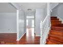 Open foyer area with hardwood floors, staircase, and neutral paint at 6955 Long Run Dr, Indianapolis, IN 46268
