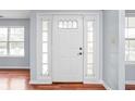 Bright foyer featuring a white front door with sidelights and hardwood flooring at 6955 Long Run Dr, Indianapolis, IN 46268