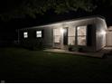 Night view of a single-story home with well-kept lawn and detached garage at 717 Berkeley Dr, Shelbyville, IN 46176