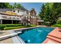 Inviting backyard pool with diving board, surrounded by lush landscaping and a spacious deck at 7341 Washington Blvd, Indianapolis, IN 46240