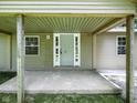 Covered front porch with gray concrete, wooden posts, and sidelights around the front door at 7434 N Green Meadows, Fairland, IN 46126