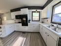 Bright kitchen featuring white cabinetry, modern appliances, and wood-look flooring at 771 Doran Ave, Shelbyville, IN 46176