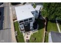Stunning aerial view of a modern three-story home with a fenced yard, patio, and lush green grass at 806 Shelby St, Indianapolis, IN 46203
