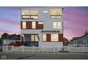 Beautiful three-story home offers modern design with white siding, wood accents, and a picket fence at 806 Shelby St, Indianapolis, IN 46203