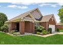 A single-Gathering home featuring a covered porch, brick facade, well-manicured lawn, and a two-car garage at 8115 Cole Wood Blvd, Indianapolis, IN 46239