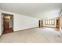 Expansive living area with neutral carpet, white walls, and natural wood trim details at 817 S Jefferson St, Brownsburg, IN 46112