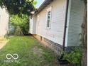 Side view of house with a glimpse of the backyard and its features at 822 W 7Th St, Muncie, IN 47302