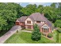 Aerial view of Tudor home, showcasing lush landscaping and mature trees surrounding the property at 8534 Helmsman Cir, Indianapolis, IN 46256