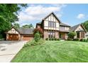 Beautiful Tudor home with a brick facade, manicured lawn, and attached two-car garage at 8534 Helmsman Cir, Indianapolis, IN 46256