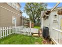 Backyard featuring a small deck, white picket fence, well-kept lawn and storage shed at 905 Buchanan St, Indianapolis, IN 46203