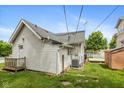 Exterior view of the home highlighting the siding, roofline, and small back porch with access to the yard at 905 Buchanan St, Indianapolis, IN 46203