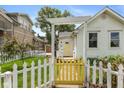 Inviting front entrance with a decorative pergola, yellow gate and door, and white picket fence at 905 Buchanan St, Indianapolis, IN 46203