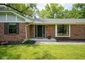 Charming brick home entrance with flower pots, decorative shutters, and a well-manicured lawn at 1015 Fox Hill Dr, Indianapolis, IN 46228