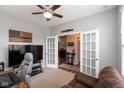 Cozy home office featuring carpet, gray walls, ceiling fan and french doors to another room at 10334 Deercrest Ln, Indianapolis, IN 46239