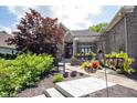 Well-manicured front yard showcasing a beautiful brick home with a pergola-covered entryway and charming accents at 10707 Burning Ridge Ln, Fishers, IN 46037
