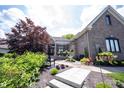 Inviting brick home with a charming front yard, adorned with lush landscaping and a cozy seating area at 10707 Burning Ridge Ln, Fishers, IN 46037