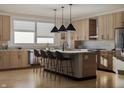 Bright kitchen boasts wood cabinets, granite countertops, modern island with seating, and stainless steel appliances at 11972 Citywalk Dr, Fishers, IN 46038
