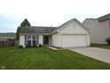 Inviting one-story home with a green lawn and a convenient two-car garage at 12389 Titans Dr, Fishers, IN 46037