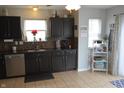 Modern kitchen featuring dark cabinets, stainless steel appliances, and tile flooring at 12389 Titans Dr, Fishers, IN 46037