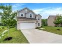 Charming two-story home with brick and siding, attached two-car garage and well-maintained lawn at 1571 N Creekwater Pass, Greenfield, IN 46140