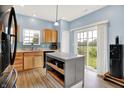 Bright kitchen with light wood cabinets, an island, and a sliding glass door to the backyard at 1571 N Creekwater Pass, Greenfield, IN 46140