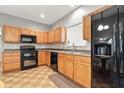 Functional kitchen featuring tile backsplash, light wood cabinetry and modern black appliances at 19489 Prairie Crossing Dr, Noblesville, IN 46062