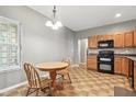 Eat-in kitchen boasts light wood cabinetry, modern appliances, and cozy dining area with great natural light at 19489 Prairie Crossing Dr, Noblesville, IN 46062