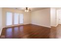 Open living room featuring hardwood floors, a ceiling fan, and doors to a patio at 209 Faulkner Ct # 102, Carmel, IN 46032