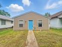 Simple home featuring horizontal siding, a well-manicured lawn, and a bright blue front door at 2524 E 17Th St, Indianapolis, IN 46218